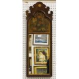 An early 20th century Queen Anne style walnut mirror, the arched frame inset with a painted panel of