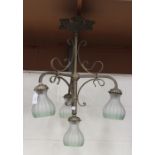 An early 20th century Gothic Revival brass four light hanging lamp with scrollwork supports and a