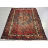 A Hamadan rug, North-west Persia, early 20th century, the red field with a stepped medallion, within