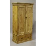 A Victorian pine two door wardrobe, fitted with a drawer and raised on a plinth base, height