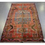 A Hamadan rug, North-west Persia, mid-20th century, the red field with a pale blue medallion, within