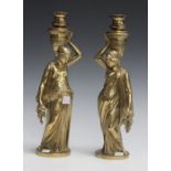 A pair of late 19th/early 20th century cast brass figural candlesticks, the circular sconces above