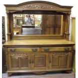 An Edwardian Art Nouveau oak sideboard, the mirrored back above a pair of drawers and three carved