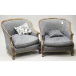 A pair of 20th century stained showframe tub back armchairs with carved decoration, upholstered in