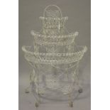 A late 19th century wirework demi-lune plant stand of three-tier graduated form, raised on