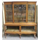 A late Victorian walnut breakfront display cabinet, the moulded pediment above three astragal glazed