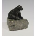 An early 20th century Continental brown patinated cast bronze model of a seated bear, raised on a