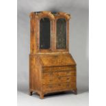 A Queen Anne and later walnut bureau bookcase, the double dome pediment fitted with two turned