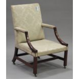 A George III mahogany Gainsborough armchair, upholstered in a cream damask, raised on block legs and