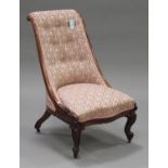 A mid-Victorian rosewood framed slipper chair with upholstered seat and back, on carved cabriole