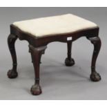 A late 19th century George I style stained walnut stool, the serpentine shaped seat raised on carved