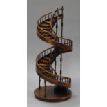 A late 20th century stained hardwood novelty model of a spiral staircase with spindle supports and a