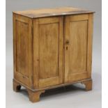 A Victorian stripped pine cupboard, enclosed by two panelled doors, on bracket feet, height 93cm,