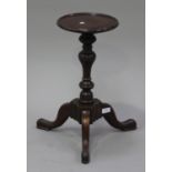 A George II and later mahogany kettle stand, the circular top above a turned baluster and knop stem,