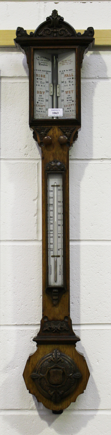 A late Victorian oak cased stick barometer with mercury thermometer, the dial with vernier scales