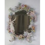 A Dresden porcelain wall mirror, early 20th century, formed from rococo 'C' scrolls with floral