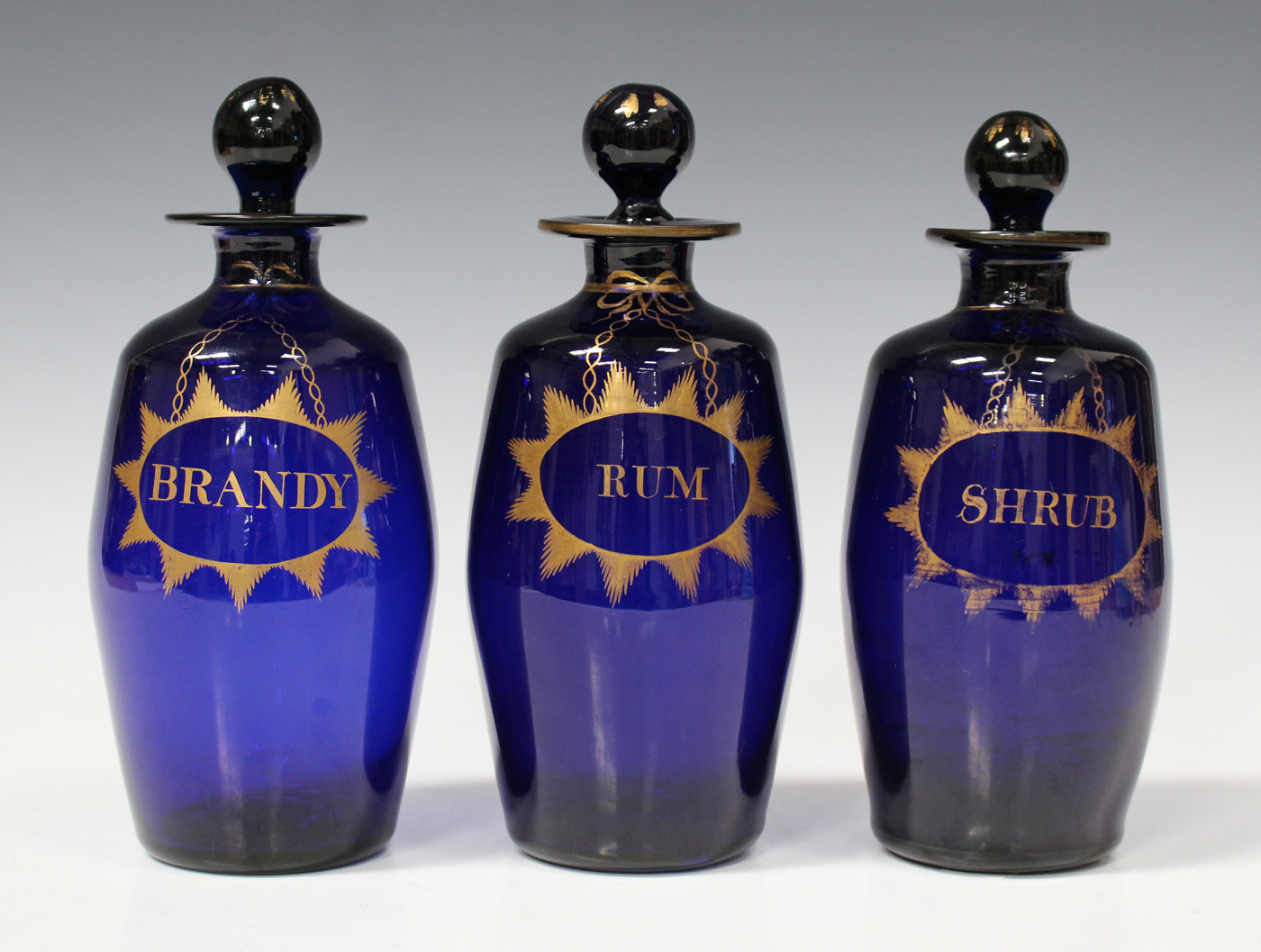 A set of three Bristol blue decanters and stoppers, late 18th/early 19th century, each of barrel