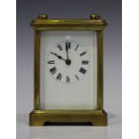 An early 20th century French brass cased carriage timepiece, the enamel dial with Roman numerals,