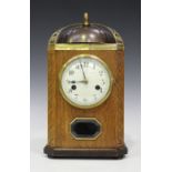 An Art Deco German oak cased mantel clock with eight day movement striking on a bell, the circular