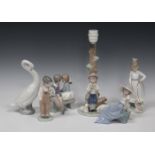 A Nao porcelain table lamp base, 20th century, modelled as a shepherd boy playing a flute beside two