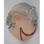 An Art Deco Beswick Ware pottery Hyacinth Lady wall plaque with puce coloured beads around her neck,