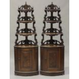 A pair of late 19th century French walnut corner cabinets with pierced and graduated shelves above