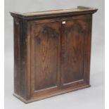 A George III oak bookcase top, the moulded pediment above a pair of panel doors revealing shelves,