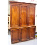 An early Victorian mahogany side cabinet, the moulded pediment above folding panel doors revealing