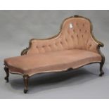 A Victorian rosewood showframe scroll end chaise-longue, carved with flowerheads and leaves,