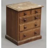 An early 20th century oak diminutive table top chest, fitted with two short and three long