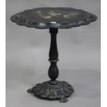 A mid-Victorian black papier-mâché oval tip-top wine table, decorated with flowers within a gilded