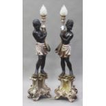 A pair of 20th century Italianate carved and moulded composition Blackamoor floor lamps, each figure