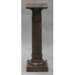 A 20th century walnut pedestal, the turned and reeded column on a platform base, height 89cm.Buyer’s