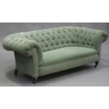 A Victorian Chesterfield settee, upholstered in green fabric, on turned feet and castors, height