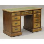 A late Victorian walnut twin pedestal desk, the moulded top inset with gilt-tooled green leather