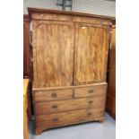 A George III mahogany linen press, the moulded pediment above a pair of panelled doors revealing