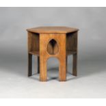 An early 20th century Arts and Crafts oak hexagonal book table, three sides pierced with teardrop