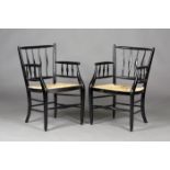 A pair of late 19th century Sussex style ebonized armchairs, possibly by Morris & Co, the