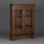 An Edwardian Arts and Crafts oak bookcase top, the two glazed doors with applied copper strapwork