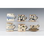 Five Nigel Lambert studio pottery mugs and a teacup and saucer, wood-fired with white slip grounds