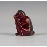 A Bernard Moore red flambé glazed model of a seated monkey, early 20th century, modelled holding a