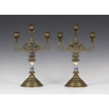 A pair of late Victorian Aesthetic period brass three light candelabra, each circular nozzle and