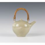 A St Ives studio pottery teapot and cover with bamboo loop handle, the ovoid body incised with