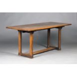 An early 20th century oak rectangular dining table, probably by Heal & Son, raised on chamfered