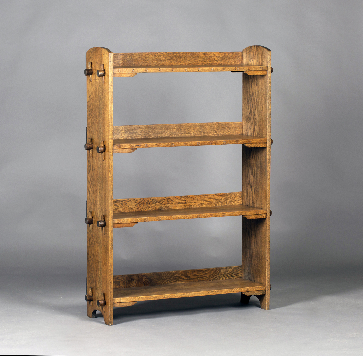 An early 20th century Arts and Crafts oak four-tier open bookcase of pegged construction, probably