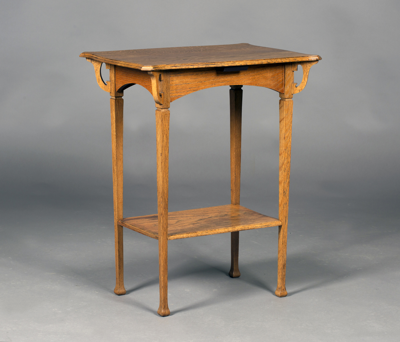 An Edwardian Arts and Crafts oak two-tier occasional table, in the manner of Shapland & Petter,