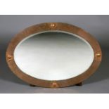 An early 20th century Arts and Crafts style copper framed oval wall mirror, 89cm x 63cm.Buyer’s