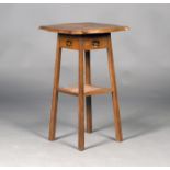 An Edwardian Arts and Crafts oak two-tier occasional table, probably by Liberty & Co, the