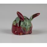 A Bernard Moore red flambé glazed menu/place holder, early 20th century, modelled as a rabbit with