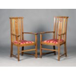 A pair of Edwardian Arts and Crafts oak elbow chairs, probably made by William Birch and designed by